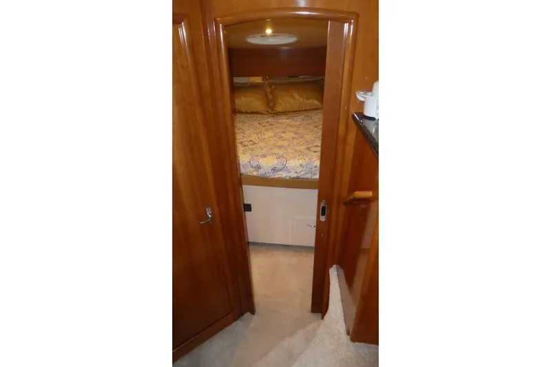 Slide: The Image of Interior view of 2006 Carver 366 Motor Yacht bedroom with wooden door and cozy bedding. - 18