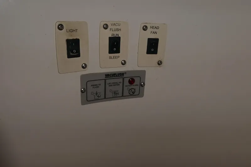 Slide: The Image of Control panel with switches for light, VacuFlush, and head fan on 2006 Carver 366 Motor Yacht. - 32