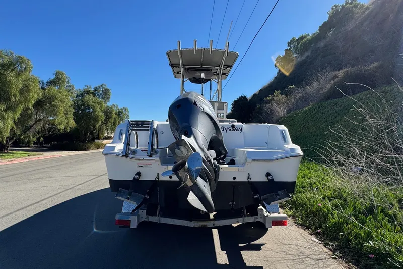 Slide: The Image of 2020 Wellcraft 222 Fisherman boat on trailer, parked on roadside with scenic background. - 10