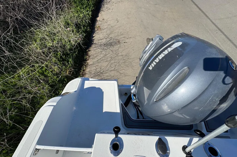 Slide: The Image of 2020 Wellcraft 222 Fisherman boat with Yamaha outboard motor, parked on a concrete surface. - 21