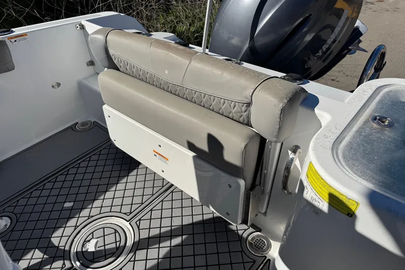 Slide: The Image of 2020 Wellcraft 222 Fisherman boat interior with cushioned seating and motor detail. - 28