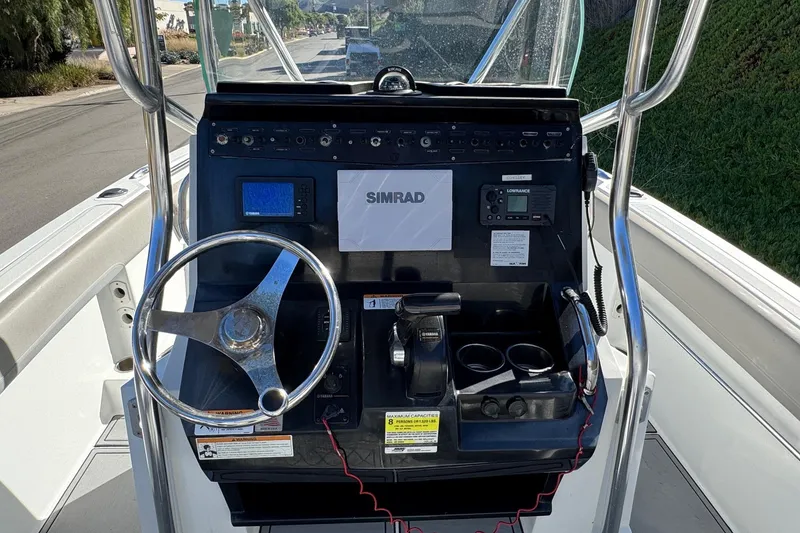 Slide: The Image of 2020 Wellcraft 222 Fisherman boat dashboard with steering wheel and navigation controls. - 36