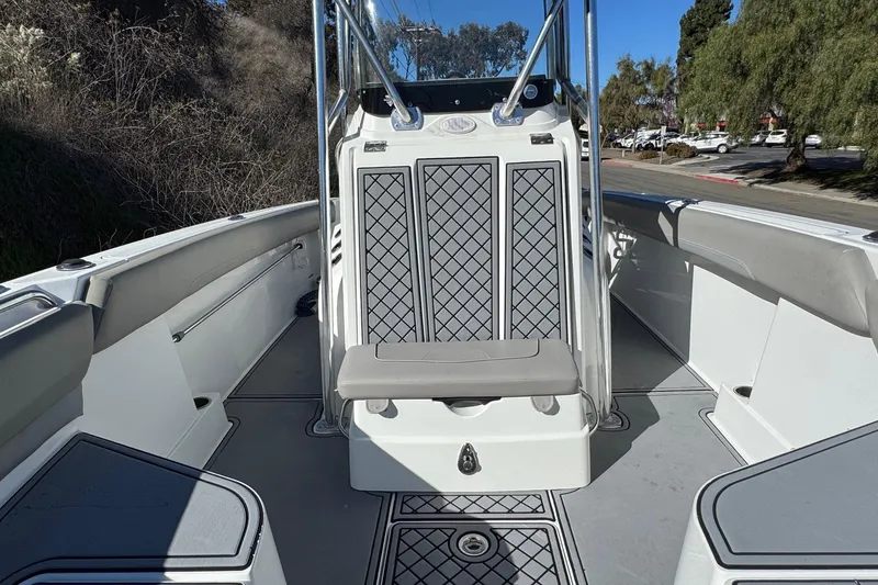 Slide: The Image of 2020 Wellcraft 222 Fisherman boat interior with seating and console, docked outdoors. - 45