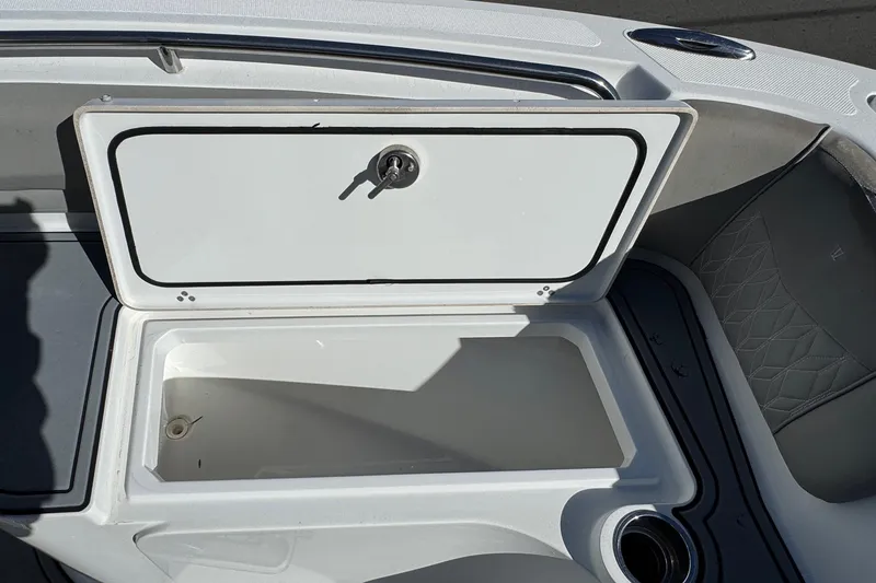 Slide: The Image of Open storage compartment on 2020 Wellcraft 222 Fisherman boat, featuring a secure latch. - 53