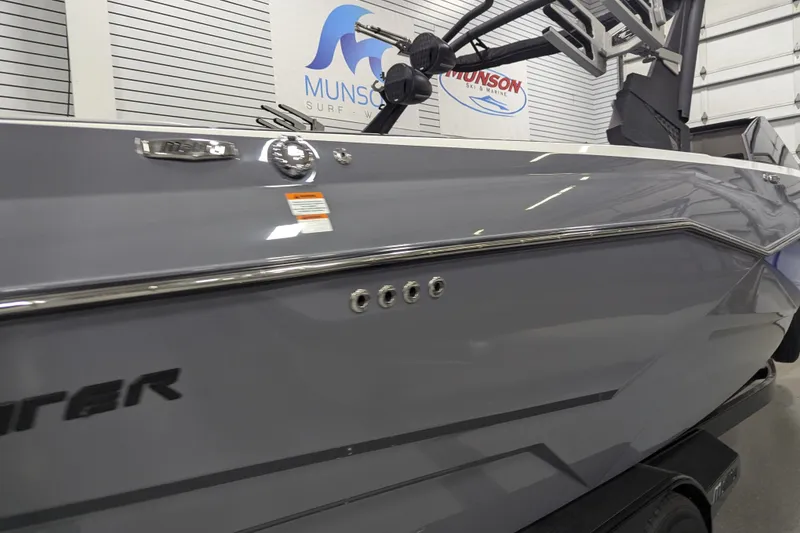 Slide: The Image of 2023 Malibu Wakesetter 25 LSV boat in showroom, sleek gray design. - 14