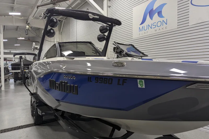 Slide: The Image of 2023 Malibu Wakesetter 25 LSV boat displayed in showroom, Munson Surf Wake branding visible. - 15