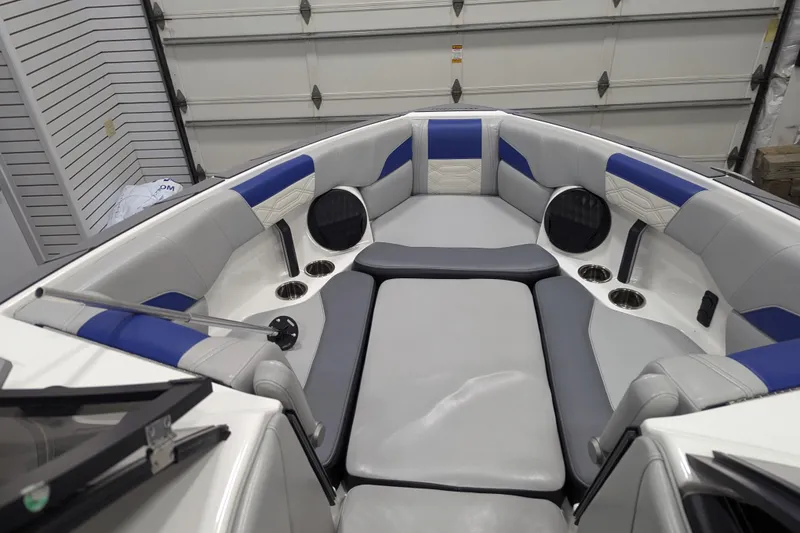 Slide: The Image of 2023 Malibu Wakesetter 25 LSV interior with blue and gray seating, cup holders, and speakers. - 27