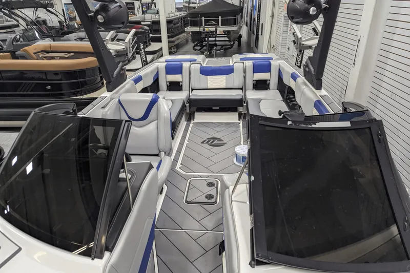 Slide: The Image of 2023 Malibu Wakesetter 25 LSV interior with blue and white seating, showcased indoors. - 29