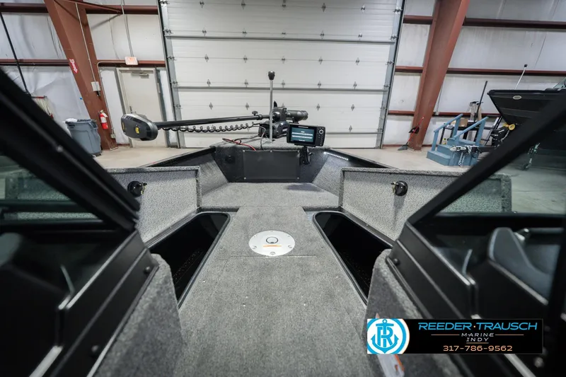 Slide: The Image of 2026 Lund 1675 Adventure Sport boat interior with fishing equipment in a garage setting. - 32