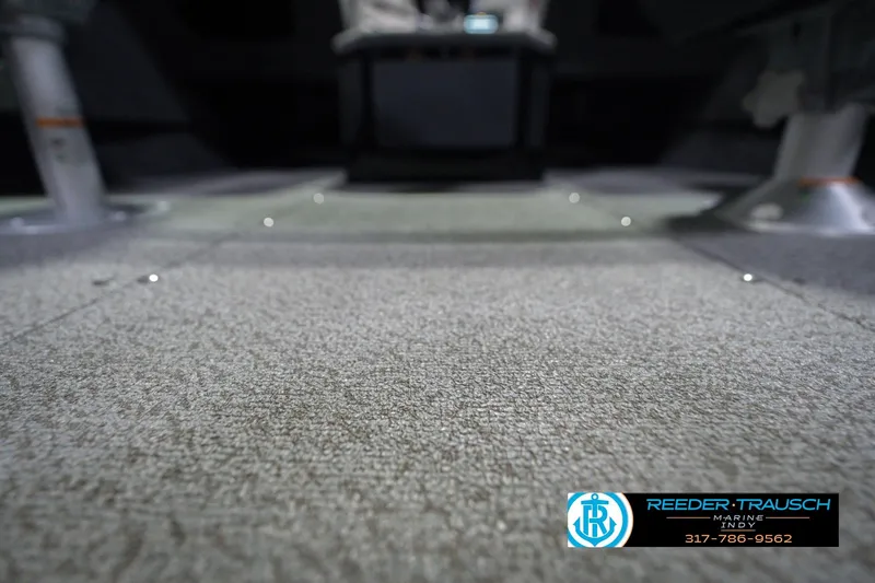 Slide: The Image of 2026 Lund 1675 Adventure Sport boat interior with carpeted flooring, Reeder-Trausch Marine logo. - 46