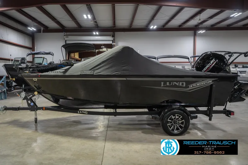 Slide: The Image of 2026 Lund 1675 Adventure Sport boat covered in a showroom, side view. - 68