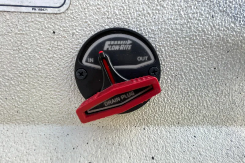 Slide: The Image of 2023 Ranger RB190 Flow-Rite drain plug with red handle on textured surface. - 12