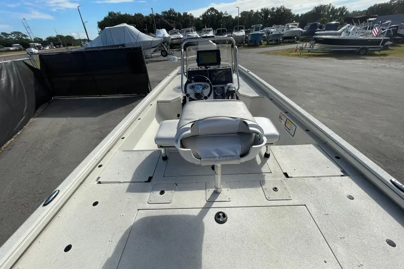 Slide: The Image of 2023 Ranger RB190 boat interior with steering console and seating, parked in a marina. - 14