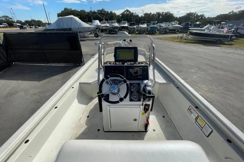 Slide: The Image of 2023 Ranger RB190 boat interior with steering console and navigation equipment, parked in a marina. - 16
