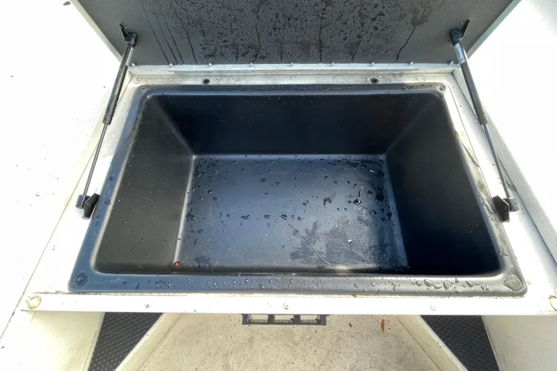 Slide: The Image of Open storage compartment in 2023 Ranger RB190 boat, showing interior with water droplets. - 35