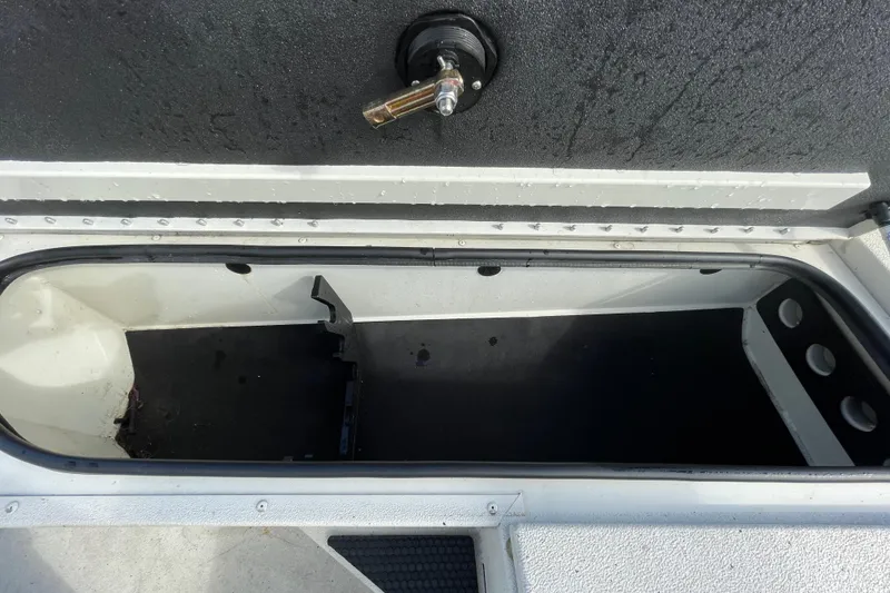 Slide: The Image of Open storage compartment in 2023 Ranger RB190 boat, featuring a black interior and latch. - 37