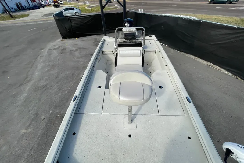 Slide: The Image of 2023 Ranger RB190 boat interior with seating and steering console, parked outdoors. - 42