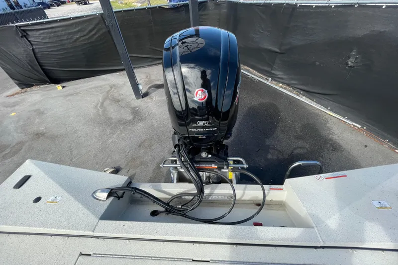 Slide: The Image of 2023 Ranger RB190 boat with powerful outboard motor in a parking area. - 57