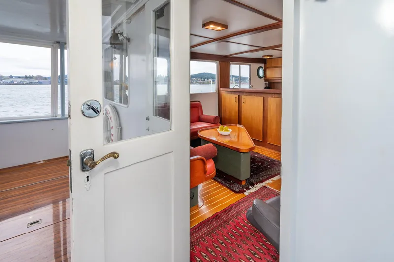 Slide: The Image of Interior of a 1966 Willard Marine 47 boat, featuring cozy seating and wooden decor. - 11