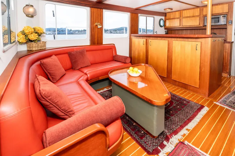 Slide: The Image of Luxurious 1966 Willard Marine 47 yacht interior with red seating, wooden accents, and scenic windows. - 13