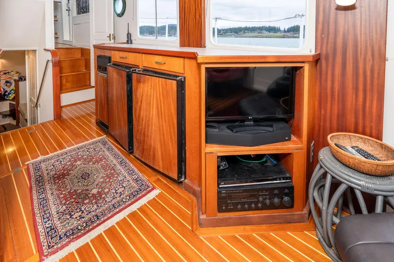 Slide: The Image of Interior of 1966 Willard Marine 47 with wood cabinetry, TV, and patterned rug. - 17