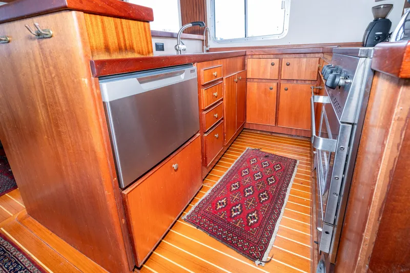 Slide: The Image of Vintage 1966 Willard Marine 47 yacht kitchen with wood cabinetry and modern appliances. - 20