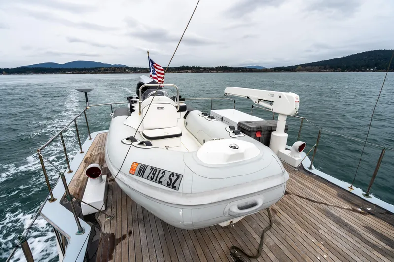 Slide: The Image of 1966 Willard Marine 47 boat with dinghy on deck, cruising on a scenic lake. - 43