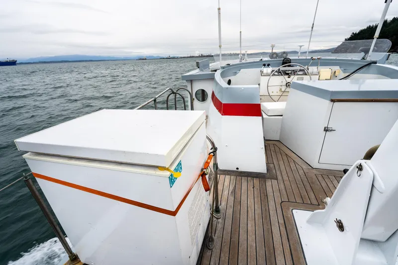 Slide: The Image of 1966 Willard Marine 47 boat deck with wooden flooring and steering wheel on open water. - 46