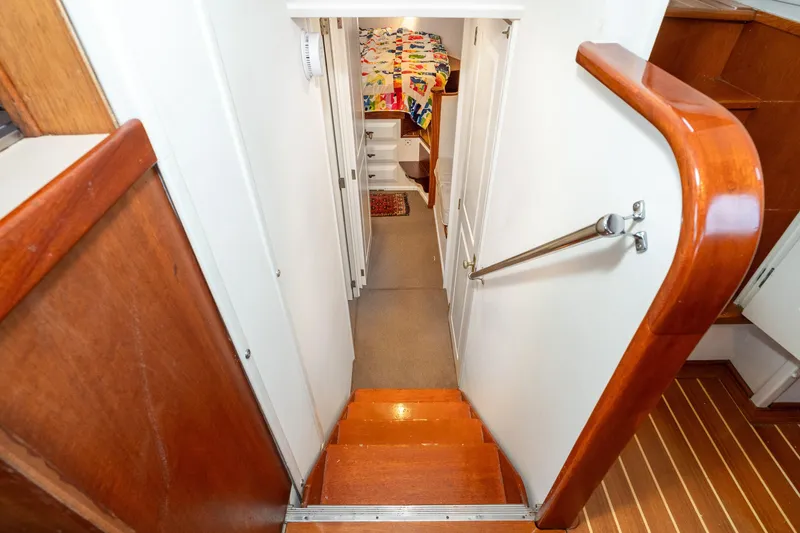 Slide: The Image of Interior of 1966 Willard Marine 47, featuring wooden stairs and cozy cabin space. - 47