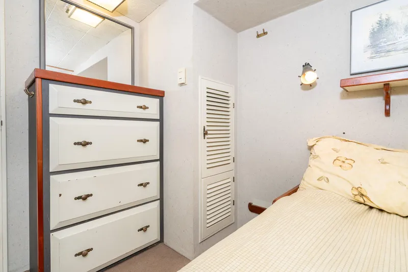 Slide: The Image of Cozy cabin interior of 1966 Willard Marine 47 with bed, dresser, and wall art. - 51