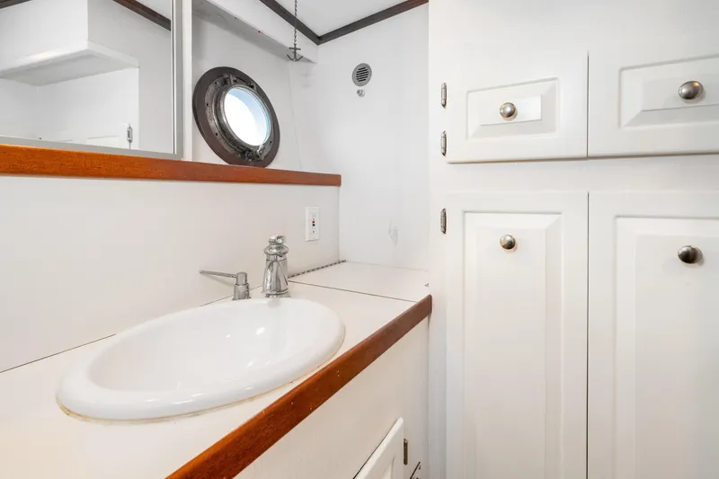 Slide: The Image of Bathroom interior of 1966 Willard Marine 47 boat with sink and porthole window. - 54