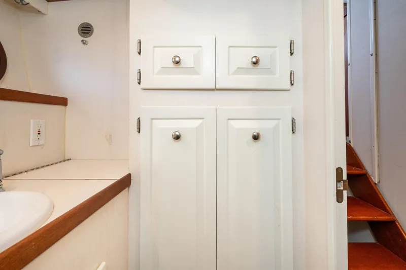 Slide: The Image of White cabinets and stairs inside a 1966 Willard Marine 47 boat. - 55