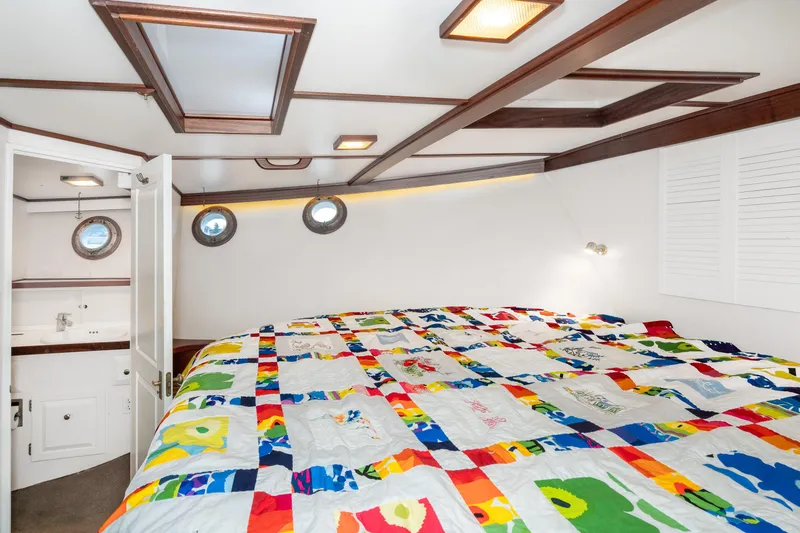 Slide: The Image of Cozy cabin interior of 1966 Willard Marine 47 with colorful quilt and porthole windows. - 59