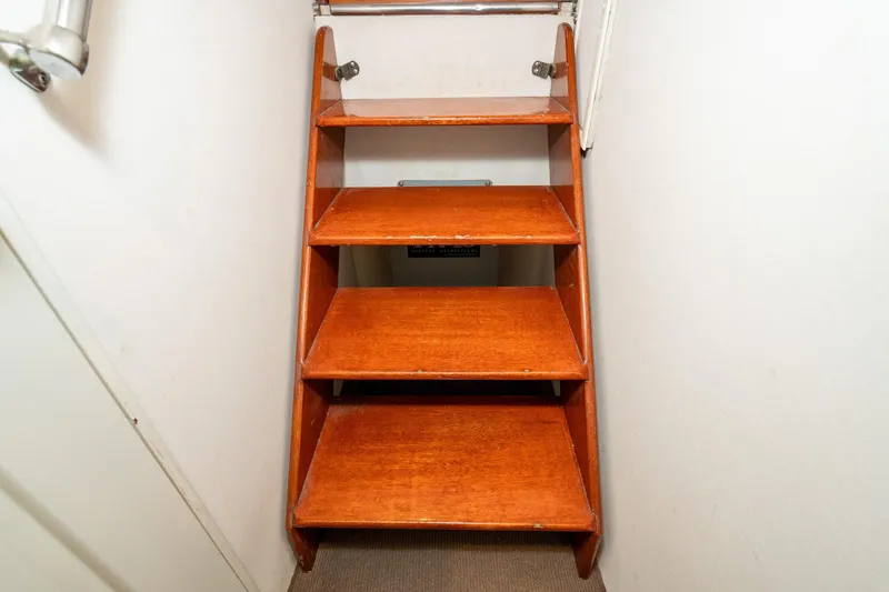 Slide: The Image of Wooden stairs inside a 1966 Willard Marine 47 boat, leading to a lower deck. - 67