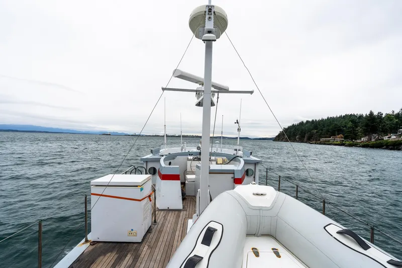 Slide: The Image of 1966 Willard Marine 47 boat on water, featuring deck and equipment, with scenic coastal backdrop. - 82