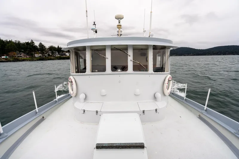 Slide: The Image of 1966 Willard Marine 47 boat on water, overcast sky, coastal landscape in background. - 87