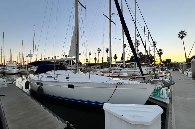 The Image of 1993 Beneteau Oceanis 440 sailboat docked at marina during sunset. - 0