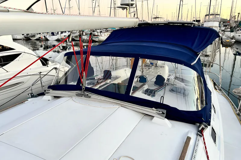Slide: The Image of 1993 Beneteau Oceanis 440 sailboat with blue canopy docked in marina. - 11