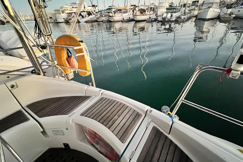 Slide: The Image of Beneteau Oceanis 440 sailboat deck, 1993 model, docked at a marina with calm waters. - 16