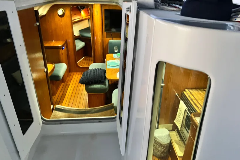 Slide: The Image of Interior view of 1993 Beneteau Oceanis 440 sailboat, featuring cozy wooden furnishings. - 21