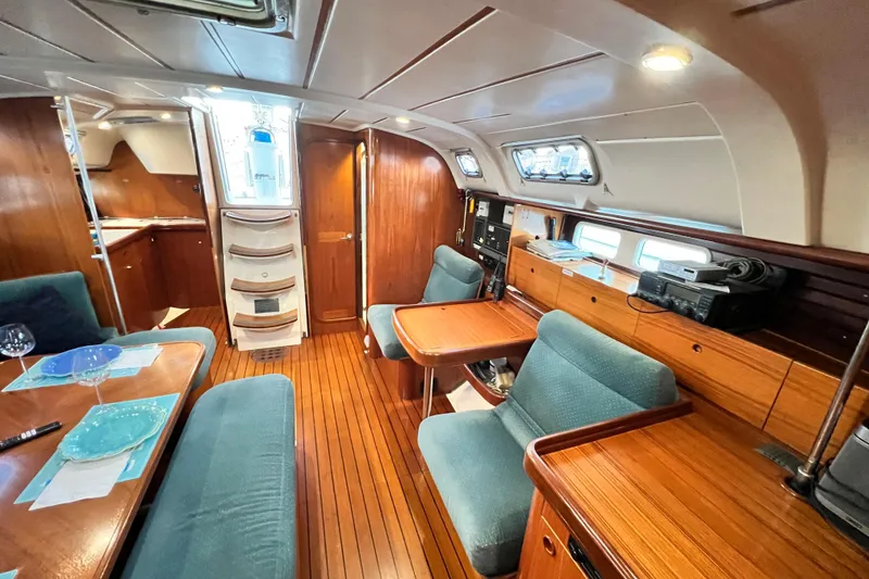 Slide: The Image of Interior of 1993 Beneteau Oceanis 440 sailboat with wooden furnishings and cozy seating. - 26