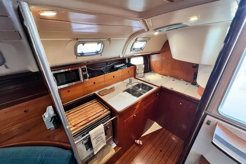 Slide: The Image of Interior of 1993 Beneteau Oceanis 440 yacht kitchen with wood cabinetry and modern appliances. - 28