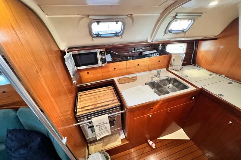 Slide: The Image of Cozy kitchen in 1993 Beneteau Oceanis 440 yacht with wood finish and modern appliances. - 29