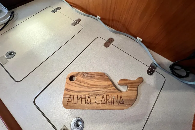 Slide: The Image of Beneteau Oceanis 440 yacht interior with wooden whale-shaped decor labeled "Alpha Carina." - 30