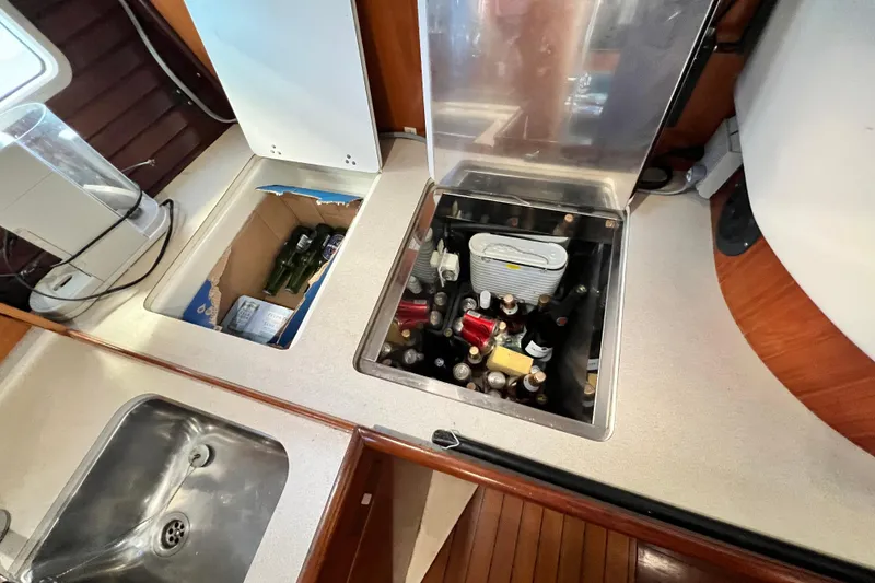 Slide: The Image of Kitchen area of 1993 Beneteau Oceanis 440 with built-in storage and sink. - 32