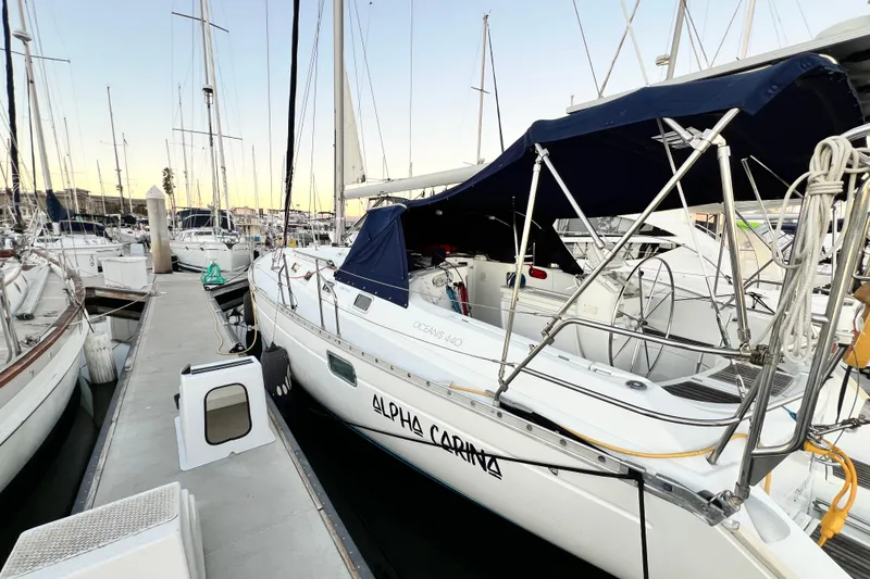 Slide: The Image of Beneteau Oceanis 440 sailboat docked at marina, 1993 model, with blue canopy. - 6