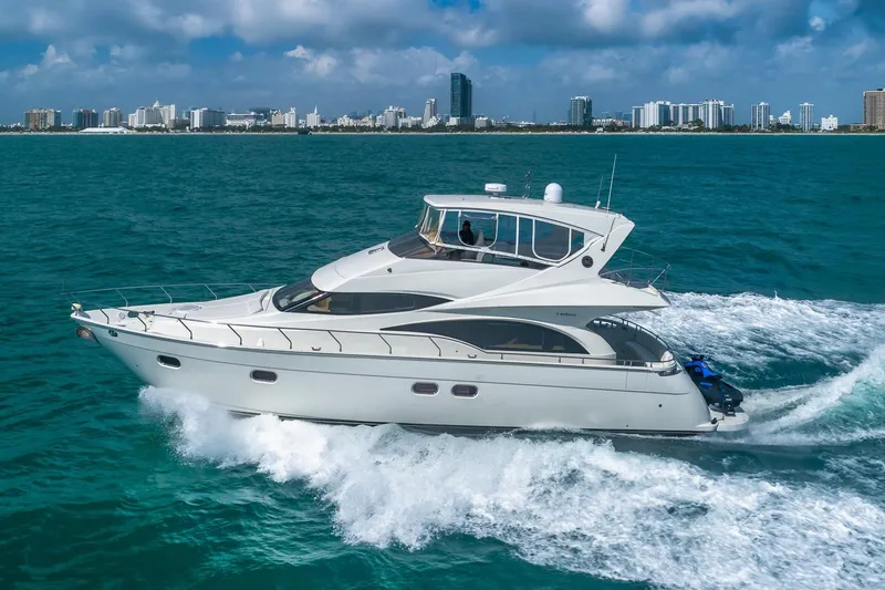 Slide: The Image of Luxurious 2005 Marquis 59 yacht cruising on blue ocean near city skyline. - 1