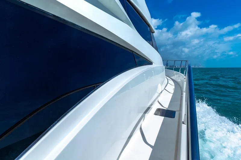 Slide: The Image of Side view of a 2005 Marquis 59 yacht cruising on the ocean under a clear blue sky. - 12
