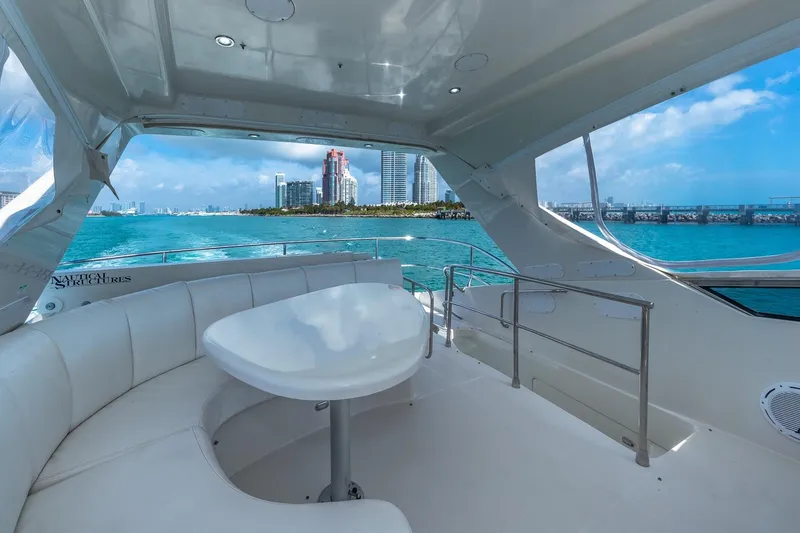 Slide: The Image of Luxurious 2005 Marquis 59 yacht interior with ocean view and city skyline in the background. - 18