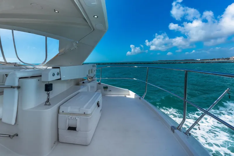 Slide: The Image of Luxury 2005 Marquis 59 yacht cruising on turquoise waters under a clear blue sky. - 22